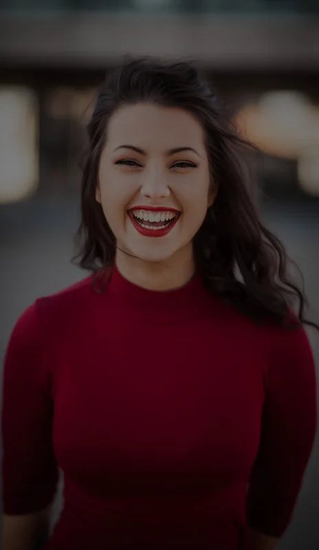 close up of young woman smiling wearing a red sweater